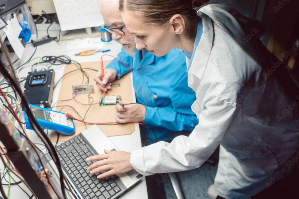 Team of development engineers designing new electromechanical device in a lab